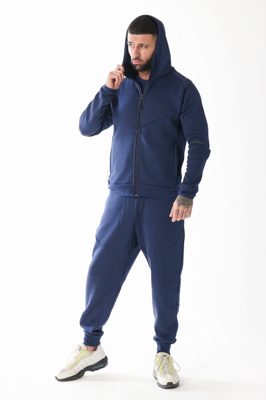 Man wearing a navy blue tracksuit on a white background