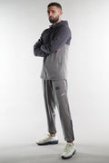 man wearing grey elegante logo tracksuit jacket and joggers on white background