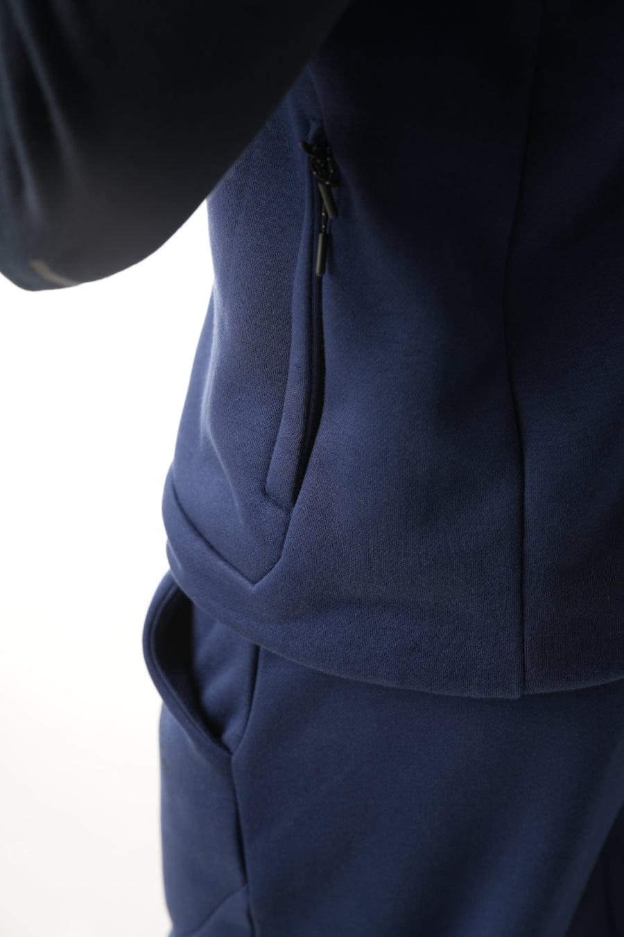 Man wearing a navy blue tracksuit on a white background