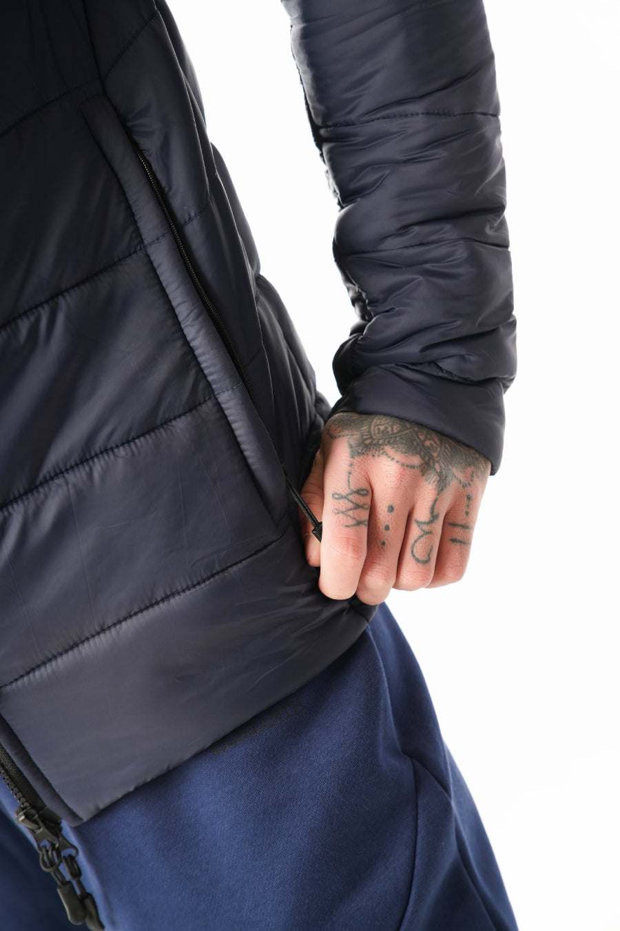 Person wearing a dark blue puffer jacket with a white background