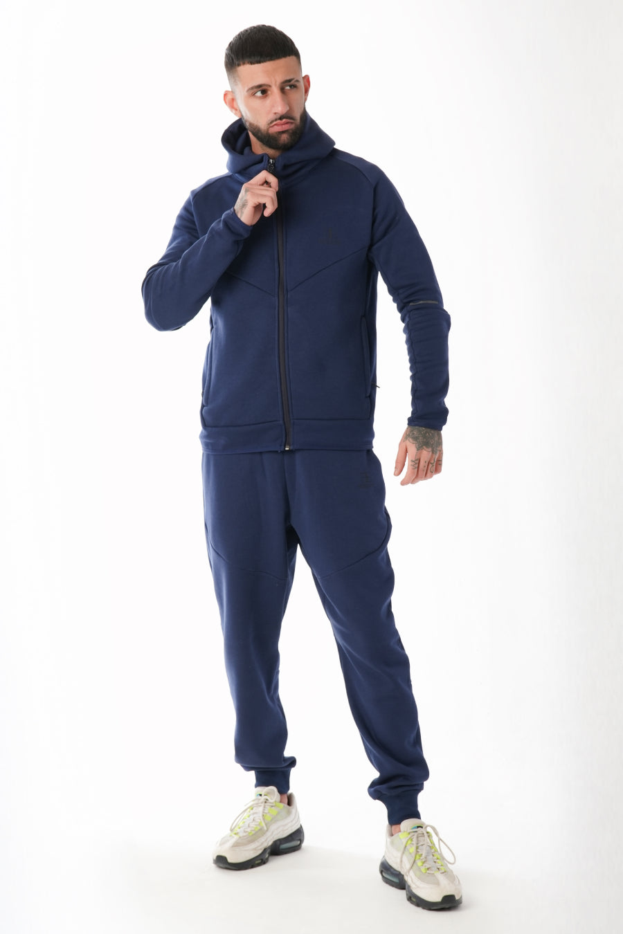 Man wearing a navy tracksuit on a white background