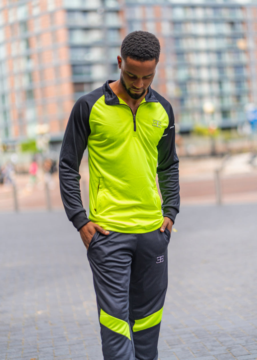 man wearing neon green/yellow tracksuit top (zip top) and black joggers in manchester