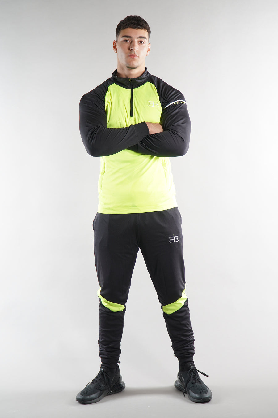 man wearing Elegante neon green tracksuit top and joggers, sportswear set for men, on white background